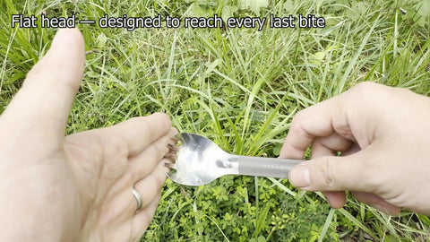 Close-up of the Ultra Lightweight Titanium Long Handle Spork With Polished Bowl For Camping And Hiking against grass background.