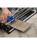 Person using 17 Inch Tile Cutter For Ceramic And Glass Mosaic Tiles, DIY Friendly Tool, cutting a brown tile on a work surface