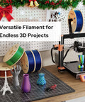 Triple Color Gradient Silk PLA Filament 1.75mm For Ender 3 V2 And More, 1Kg Spool, Red Blue Green, spools on desk with 3D printer.