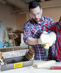 Father and son using Heavy Duty 115 Piece M35 Cobalt Drill Bit Set for drilling into wood in a workshop.
