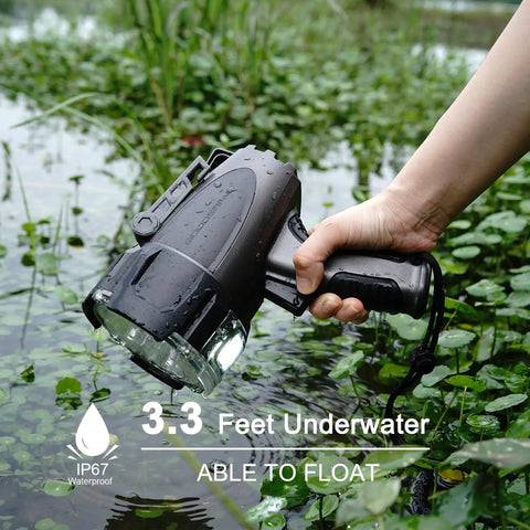 Hand holding 6000 Lumen Waterproof Marine Spotlight with Rechargeable LED Battery, partially submerged in water, showcasing its float capability.