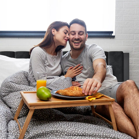 Couple enjoying breakfast in bed on Heavy Duty Velvet Full Bed Frame With Piano Keys Headboard And Matching Footboard, stylish and cozy.