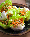 Plate of lettuce wraps filled with shredded vegetables and herbs, showcasing use of Over 20,000 Lettuce Seeds Pack With 10 Fresh Varieties For Indoor Or Outdoor Growing No Fuss Easy Grow For Beginners Great For Hydroponics Kit Non GMO Lettuce Mix For Crisp Salads Sandwiches And Wraps.