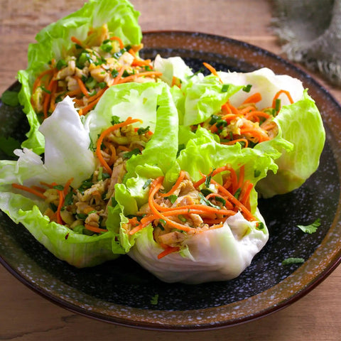 Plate of lettuce wraps filled with shredded vegetables and herbs, showcasing use of Over 20,000 Lettuce Seeds Pack With 10 Fresh Varieties For Indoor Or Outdoor Growing No Fuss Easy Grow For Beginners Great For Hydroponics Kit Non GMO Lettuce Mix For Crisp Salads Sandwiches And Wraps.