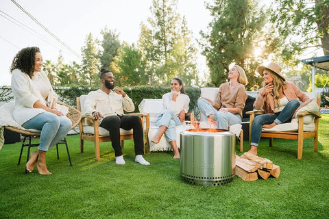 Group enjoying Bonfire Smokeless Fire Pit With Stand, 19.5 Inch Portable Stainless Steel Wood Burning Outdoor Fireplace with Removable Ash Pan in garden
