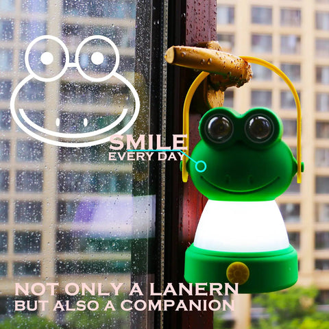 Green frog-shaped LED lantern hanging on window for Owl Themed Kid Friendly LED Lantern And Headlamp Set Battery Powered Lit Night Light For Emergency And Camping Lightweight Tent Lamp For Children Perfect For Hurricanes And Backyard Adventures.