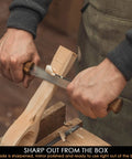 Hands using a Straight Draw Knife For Wood Carving Featuring Hella Comfy Solid Oak Handles Coated In Natural Linseed Oil on wood.