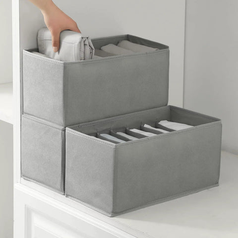 Hand adjusting Three Pack Clothes Organizer Bins With Seven Grid Compartments, Stackable Drawer Dividers For Wardrobe on shelf