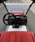 Heavy Duty Six Passenger Electric Golf Cart With Six Point Three Kilowatt AC Motor And Forty Eight Volt Electronics Built In Solar Panels Remote Key Fob And Dope Candy Apple Red Paint For No Sweat Fairway Cruising interior view with steering wheel and red seats.