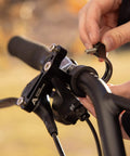 Installing Locking Bike Water Bottle Holder Adapter for Handlebar or Seat Post Black Anodized Cage Mount on bike handlebar close-up