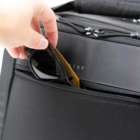 Person placing sunglasses in the front pocket of the Ascend Flight Bag For Pilots: The All In One Carry Bag For Aviation Gear