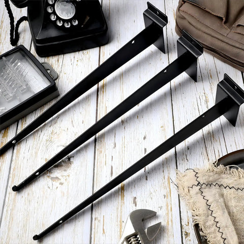 Three black 12 inch slatwall shelf brackets with lip, heavy duty metal, displayed on wooden surface with tools, bulk pack of 30.