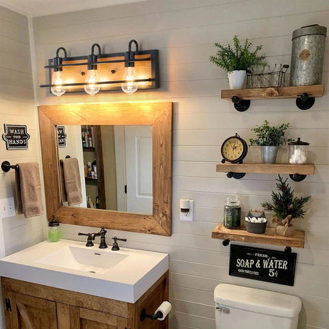 Rustic Three Light Vanity Fixture With Industrial Black Finish And Faux Wood Back Panel in bathroom setting