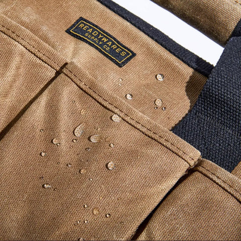 Close-up of Heavy Duty Waxed Canvas Tool Bag with 11 Pockets showing water-resistant material details and stitching.