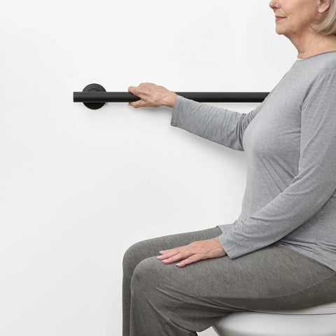 24 Inch Straight Shower Grab Bar Matte Black Stainless Steel With Concealed Flanges for support in a bathroom setting.