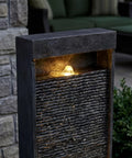 35 Inch Outdoor Water Fountain With Modern Curved Faux Slate Resin Waterfall And 2 Warm LED Lights For Garden Patio Yard Deck Porch Balcony Decor Home Art Water Feature In Black Keeps Your Outdoor Vibe On Point, showing illuminated water flow.