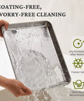 Person rinsing a stainless steel baking pan from the Stainless Steel Baking Sheet Set With Wire Racks Includes 3 Pans And 3 Racks In 9 12 16 Inch Sizes Non Toxic PFOA PTFE Free Warp Resistant Durable Oven And Toaster Safe Navy Finish For Go To Everyday Baking, showing water hitting the surface.