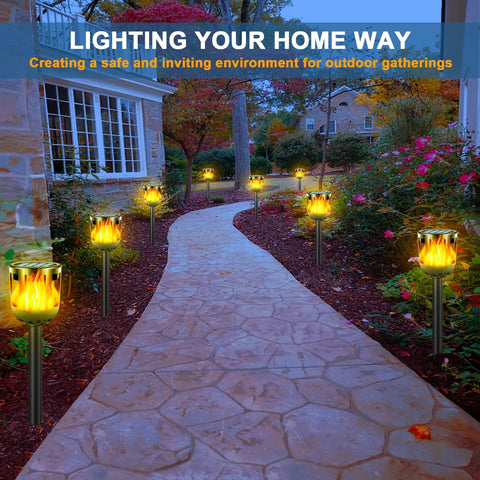 Solar Tiki Torches With Flickering Flame Outdoor Solar Lights Waterproof Auto On Off Solar Powered Decorative Lighting For Garden Yard Landscape Patio Driveway Walkway Pathway lighting a stone pathway in a garden.