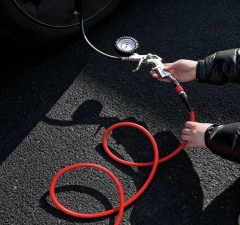 Person using a gauge on a 3/8 Inch By 100 Ft Heavy Duty Hybrid Air Compressor Hose for tire inflation.