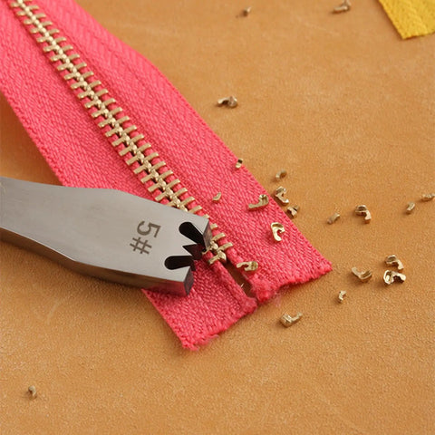 Close-up of Pro Grade Zipper Teeth Remover Tool removing teeth from a zipper on a pink fabric, showing stainless steel construction.