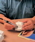 Person using Big League Air Scribe Engraving Pen With Rolling Throttle And 13500 Blows Per Minute for detailed etching on a sculpture.