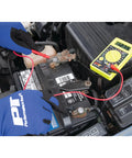 Digital Multimeter Tester 2000 Counts With AC DC Voltmeter Ohm Volt Amp Meter in use on car battery by gloved hands