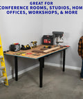Heavy Duty VIVO 4 Leg Black Electric Dual Motor Standing Desk Frame For 60-130 Inch Tops, Solid Height Adjustable Sit Stand Base Table Support Platform in a workshop setting with tools.
