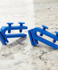 Adjustable Abs Hose Holder Clamps for Bucket and Garden Hose Storage 2 Pc Set on a stone surface