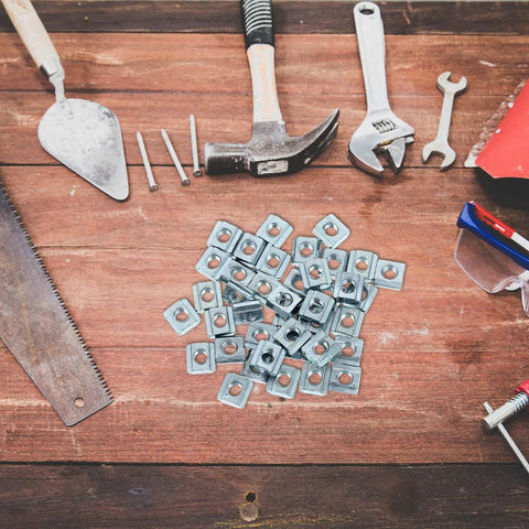 Forty Pack Carbon Steel T Slot Nuts scattered on a wooden workbench with tools for aluminum extrusion projects.