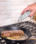 Top Rated No. 1 Instant-Read Thermometer For Precision Cooking, One-Second Read, measuring steak temperature in skillet.