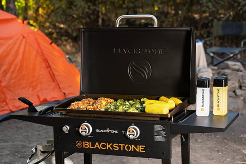28 Inch Griddle With Protective Hood And Counter Height Side Shelves In Powder Coated Steel For Outdoor Grilling, 524 Square Inches Of Cooking Space; cooking vegetables and corn in outdoor setting.