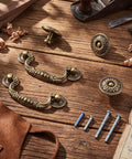 12 Piece Bail Handle Drop Pulls And Vintage Flower Cabinet Knobs In Antique Bronze Beaded Style on wooden surface