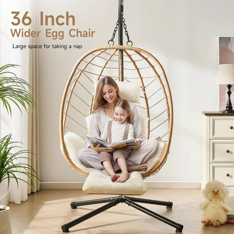 Mother and child sitting in a wicker rattan hanging egg chair with cushion, 36-inch size, indoors with plants and toys.
