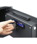 Hand inserting batteries into LED keypad of Heavy Duty Depository Safe With Front Slot Cash Drop Box Featuring LED Keypad And Wall Or Floor Mount