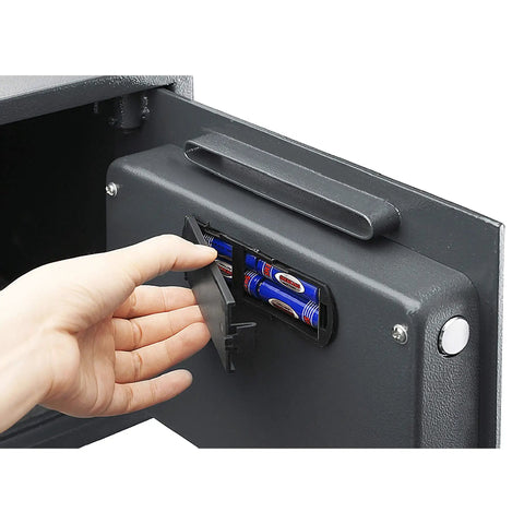 Hand inserting batteries into LED keypad of Heavy Duty Depository Safe With Front Slot Cash Drop Box Featuring LED Keypad And Wall Or Floor Mount
