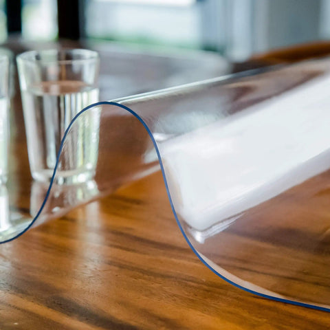 Clear Plastic Table Cover Protector 60x36 Inches Vinyl Tabletop Shield on wooden table with glass of water