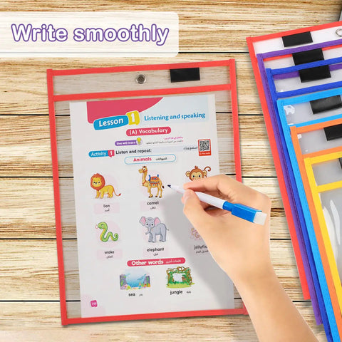 Hand using blue pen on worksheet inside colorful dry erase pockets set 6 pack 10 by 13 inch reusable plastic sleeves for classroom use.