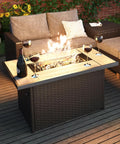43 Inch Outdoor Gas Fire Pit Table With 60,000 BTU Propane Heat, CSA Safety Approved, Rectangle Fire Pit With Ceramic Tile Top And Wicker Base, Push Button Ignition, Your Go To Patio Dining Or Coffee Table with wine glasses, wicker chairs, and lit flame on wooden deck