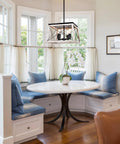 Farmhouse Chandelier For Dining Room And Kitchen Island Rustic White Wood Pendant Light hangs over a breakfast nook with blue cushions.
