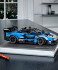 Technic McLaren Senna GTR 42123 Racing Collectible Model Car Build Kit displayed on a black book with orange pen nearby