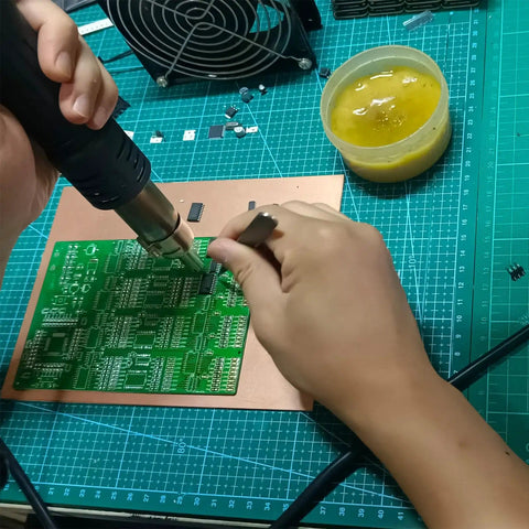 Hands soldering a circuit board using the Advanced SMD and SMT Soldering Practice Kit for Pro Electronics Hobbyists DIY Training Board With 313 Components And 1079 Precision Solder Points EK8489.