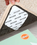Hand lifting rug corner showing 12 Pack Rug Tape Gripper For Hardwood Floors Double Sided Reusable Under Rug Tape on wooden floor.