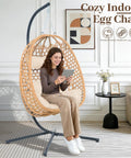 Cozy Hanging Egg Chair With Stand And Plush Cushions for Indoor Outdoor Chill Sessions, all-weather rattan swing seat viewed indoors.