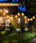 Outdoor String Light Poles 8.9ft Heavy Duty Poles With 5 Prong And Hooks in a backyard setting at night, matte black finish