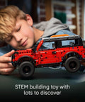Child playing with Ford Bronco Technic Off Road SUV Building Kit For Kids 9 And Up With Realistic Suspension Opening Doors Steering