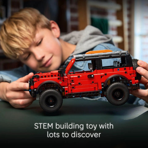 Child playing with Ford Bronco Technic Off Road SUV Building Kit For Kids 9 And Up With Realistic Suspension Opening Doors Steering