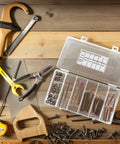 Open box of 49Pc M6 Hex Socket Head Screws And Barrel Nuts Set For Furniture Connectors on a wooden surface.