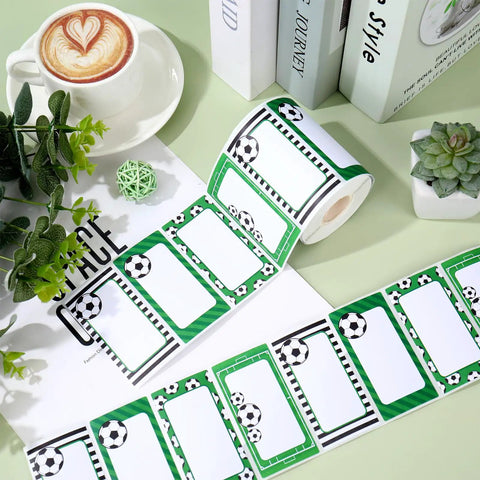 Roll of 400 Soccer Name Tag Stickers Set In Green And Black With 4 Designs Adhesive Label Decals on desk with plants
