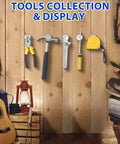Tools collection on wooden wall with pliers, hammer, wrench, screwdriver, and tape measure alongside guitar and lantern.