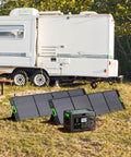 Heavy Hitter 2400W Portable Power Station With 1843Wh Battery Capacity And Dual 200W Solar Panels For Off Grid Camping And Whole Home Backup Take Charge next to a trailer in a grassy area.